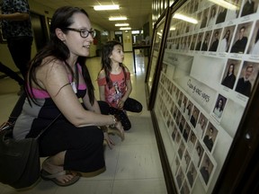 Samantha Sowden looks through graduation photos of her classmates from 1993, as her daughter Julianna looks on, at the Riverdale High final good-bye which was held recently in Pierrefonds.