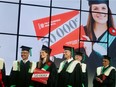 Eva Terriault, the 50,000th graduate of École Polytechnique, accepts her diploma from Pierre Langlois, left, and Yves Boudreault.