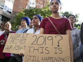 Protesters stand outside Quebec Premier Francois Legault downtown Montreal office on Monday June 17, 2019, to denounce the adoption of Bill 21.