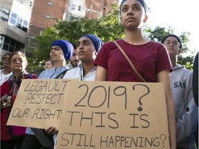 Protesters stand outside Quebec Premier François Legault's downtown Montreal office on June 17, 2019 to denounce the adoption of Bill 21.