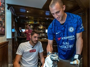 Montreal Impact goalkeeper Evan Bush waited at the table of James Pantemis, also an Impact goalkeeper, at the Burgundy Lion Pub in Montreal on Wednesday, June 19, 2019, after losing a bet over the Europa League final with the co-owner of the Burgundy Lion Pub, Paul Desbaillets.