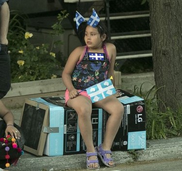 A youngster waits for the Fête Nationale parade to start on St. Denis St. in Montreal on Monday, June 24, 2019.