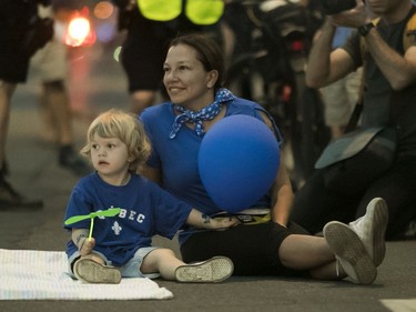 Caroline Bélanger and her son Joseph watch the parade for Fête Nationale on St-Denis St. In Montreal Monday, June 24, 2019.