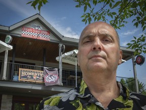 Bob Simotas, outside his bakery and pub, said the city of Beaconsfield informed him that some of his signs don't comply with certain bylaws.