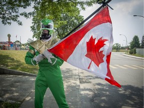 Dressed in the Power Ranger outfit, Gerry Osei-Agyemang celebrates Canada day waving the flag as as he tours the Pierrefonds carnival area Canada Day in Pierrefonds, Sunday, July 1, 2018.