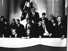 Prime Minister Pierre Elliott Trudeau (seated, centre) watches calmly as a demonstration flares near the reviewing stand for the St. Jean Baptiste Day parade in Montreal on June 24, 1968. This photo was published in the Montreal Gazette the following day.