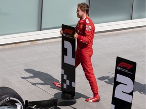 Scuderia Ferrari Mission Winnow driver Sebastian Vettel (5) of Germany moves the 2nd place banner in from tof Mercedes AMG Petronas Motorsport driver Lewis Hamilton (44) of Great Britain's car after race officials took the win away from Vettel during the Canadian Grand Prix at the Circuit Gilles Villeneuve in Montreal, on Sunday, June 9, 2019.