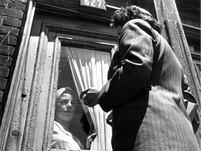 In this photo dated June 30, 1951, a housewife peers out at a census taker.