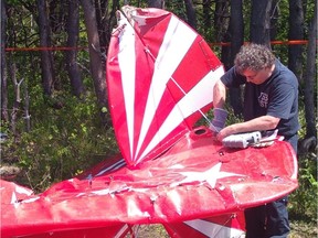 In a photo released by the Transportation Safety Board of Canada, an investigator examines a Pitts S2E aircraft that crashed on takeoff at the St-Jean-Port-Joli airport, killing one person and injuring another, on June 17, 2019.