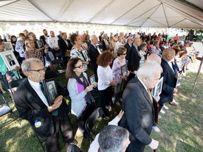 Children and grandchildren of Italian Canadians interned during the Second World War hold their family members' portraits Sept. 18, 2018 at a ceremony in Ottawa marking the RCMP's issuing of a Statement of Regret for the force's participation in the internment.