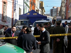 Police officers of the homicide brigade inspect the place where a Canadian citizen was killed when he was walking with his family in a touristic hill of Valparaiso, Chile, on Friday, June 21, 2019.