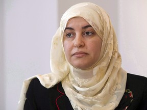Rania El-Alloul takes part in a news conference Friday, March 27, 2015, in Montreal. The disciplinary case against a Quebec judge who refused to allow a Muslim woman to appear before her wearing a hijab more than four years ago was put on hold again Friday.