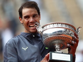 Rafael Nadal of Spain bites the trophy after defeating Dominic Thiem of Austria in the final during Day Fifteen of the 2019 French Open at Roland Garros on June 9, 2019, in Paris.