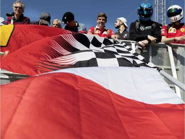 Fans hold large Ferrari flags as they wait for autographs during the annual Grand Prix open house at Circuit Gilles Villeneuve  in Montreal on Thursday, June 6, 2019.