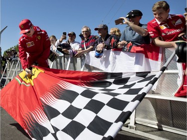 Scuderia Ferrari Mission Winnow driver Charles Leclerc (16) of Monaco signs a fan's flag during the annual Grand Prix open house at Circuit Gilles Villeneuve  in Montreal on Thursday, June 6, 2019.