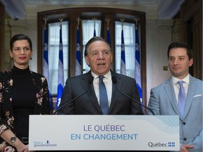 Quebec Premier Francois Legault speaks during a end of session wrap up news conference, Friday, June 14, 2019 at his office in Quebec City. Legault is flanked by Quebec Deputy premier and Public Security Minister Genevieve Guilbault, left, and government House Leader and Minister of Immigration, Diversity and Inclusiveness Simon Jolin-Barrette.