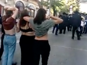 A screenshot from a video capturing waitresses flashing their bras.