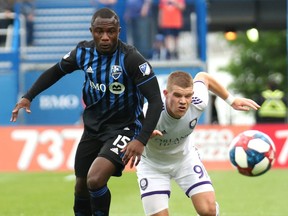 Jun 1, 2019; Montreal, Quebec, CAN; Montreal Impact defender Zachary Brault-Guillard (15) and Orlando City forward Chris Mueller (9) chase the ball during the first half at Stade Saputo.
