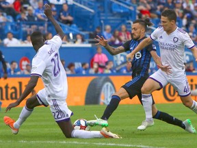 Impact forward Maximiliano Urruti battles Orlando City defender Ludovic Lamine Sané (22) and midfielder Will Johnson (4) for the ball at Saputo Stadium. Urruti is one of only two Impact players who will earn more than $1 million this season.