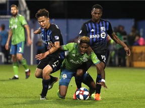 Seattle Sounders midfielder Joevin Jones falls between Montreal Impact midfielder Ken Krolicki, left, and midfielder Omar Browne during the second half of the Impact’s 2-1 win at Saputo Stadium on June 5. Browne, who is playing in the Gold Cup tournament with Panama, will miss the Impact’s home game Wednesday against the Portland Timbers.