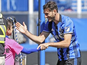 Impact midfielder Ignacio Piatti celebrates with a ball boy after scoring on a penalty kick during MLS game against the Portland Timbers at Montreal’s Saputo Stadium on May 20, 2017.