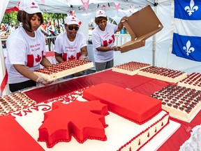 Volunteers Christine Busby, Dorothy Champagne, and Jean Harry unboxed and guarded the birthday cake that was served to the public at Place du Canada at the finish of Montreal's Canada Day parade.