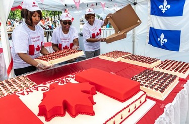 Volunteers Christine Busby, Dorothy Champagne, and Jean Harry unboxed and guarded the birthday cake that was served to the public at Place du Canada at the finish of Montreal's Canada Day parade.