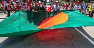 A hot sun beat down on the Bangladeshi flag reflecting the flag's red dot onto Rene Levesque Blvd. during the Canada Day Parade in Montreal on Monday July 1, 2019.