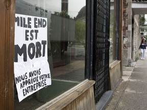 A Mile End is Dead sign sits in an empty business' window on Saint-Viateur Street in Montreal.