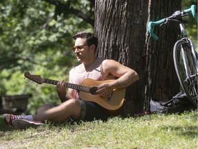 Johnnie Palazzo enjoys the sun while playing his guitar in Lafontaine Park on Thursday July 18, 2019.