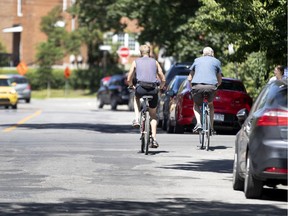 Two cyclist ride side by side along Isabella street in Montreal.