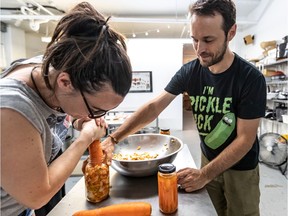 In one of his fermentation workshops, Jean-Luc Henry watches as Michelle Poirie packs kimchi into a jar.