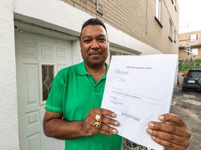 Ashton Boodoo, who is suing the city of Montreal and SPVM officers for a 2015 arrest he feels was the result of racial profiling, is seen holding the 78-page favourable judgment at his former address in LaSalle on Tuesday, July 23, 2019, where he was arrested by police officers.