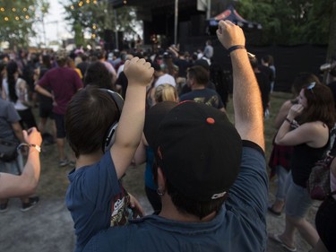 A man and a boy raise their fists during a performance by Cro-Mags at the '77 Montréal punk festival at Parc Jean-Drapeau in Montreal Friday, July 26, 2019.