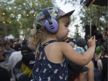 A little girl works on making the devil horns with her fingers as the band Cro-Mags perform at the '77 Montréal punk festival at Parc Jean-Drapeau in Montreal on Friday, July 26, 2019.