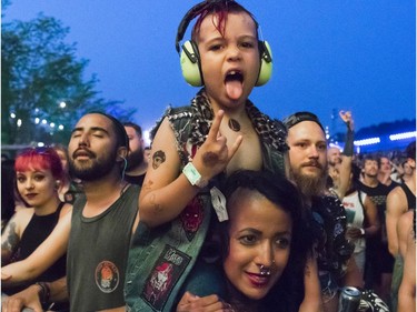 Jason Brousseau and his mother, Sharon Pinheiro, enjoy the band Streetlight Manifeso as they perform at at the '77 Montréal punk festival at Parc Jean-Drapeau in Montreal on Friday, July 26, 2019.