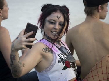 Céleste Summer takes video of men dressed as Super Mario Brothers as they frolicked in the fountain at the Heavy Montréal metal festival July 28, 2019, at Parc Jean-Drapeau.