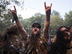 A man raises his hands as the band Demolition Hammer played on day 2 of the Heavy Montréal metal festival on Sunday, July 28, 2019 at Parc Jean-Drapeau in Montreal.