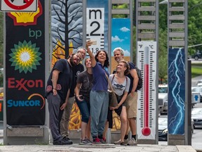 Montreal artist Roadsworth (a.k.a. Peter Gibson, far right) collaborated with Greenpeace on an installation that went up Wednesday at de la Gauchetière St. and Robert-Bourassa Blvd.