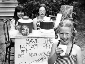 Girls in Westmount sell Kool-Aid  to raise money for Vietnamese refugees on July 20, 1979.  From left: Vanessa Zorbos, 10, and Cassandra Prince, 11, at their stand at the corner of de Maisonneuve Blvd. and Metcalfe Ave., just east of Westmount Park. In the foreground is six-year-old Ada Mullet.