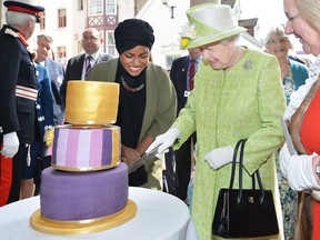 Queen Elizabeth II receives a birthday cake from Nadiya Hussain, winner of the Great British Bake Off, during her 90th Birthday Walkabout on April 21, 2016 in Windsor, England.