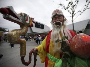 A man depicting the God of Longevity, one of the Chinese Three Lucky Gods through the site at the Shanghai World Expo Saturday May 8, 2010 in Shanghai, China.