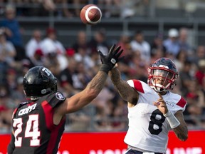 Redblacks defensive-back Anthony Cioffi tried to block a pass from Als quarterback Vernon Adams Jr. during action in Ottawa on July 13. Prospective Alouettes owner Jeffrey Lenkov was seen with his arm around the Montreal QB after the game.