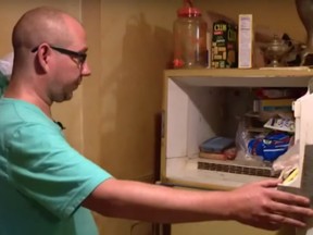 Adam Smith, 37, opens the freezer in his mother's St. Louis apartment.