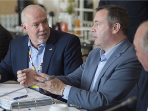 British Columbia Premier John Horgan speaks with Alberta Premier Jason Kenney during a meeting of Canada's Premiers in Saskatoon, Sask. Wednesday, July 10, 2019.