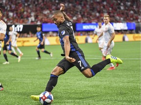 Montreal Impact midfielder Harry Novillo (7) takes a shot against Atlanta United defender Miles Robinson (12) during the first half at Mercedes-Benz Stadium.