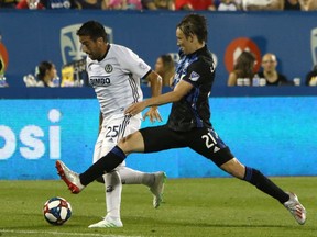 Montreal Impact midfield Lassi Lappalainen (21) and Philadelphia Union midfielder Ilsinho (25) battle for the ball during the second half at Saputo Stadium.