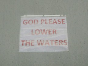 A sign reading God Please Lower The Water is seen on a flood gate in Morgan City, Louisiana, Saturday, July 13,2019 ahead of Tropical Storm Barry.