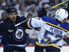 Winnipeg Jets defenceman Ben Chiarot, left), battles St. Louis Blues forward David Perron during Game 5 in Winnipeg on April 18, 2019.