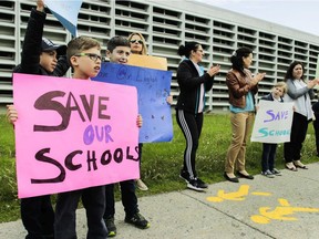 Students, parents and teachers formed a chain around General Vanier Elementary School in June to protest the transfer of the building from the EMSB. Despite the transfers of General Vanier and John Paul I Junior High's buildings, the two schools are keeping their own identities, EMSB spokesperson Mike Cohen says.